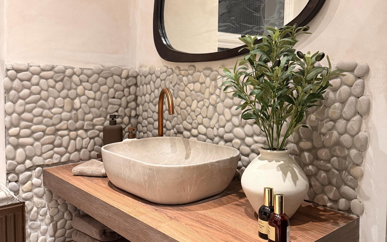 Natural stone washbasin, soft towels and plants in the salon